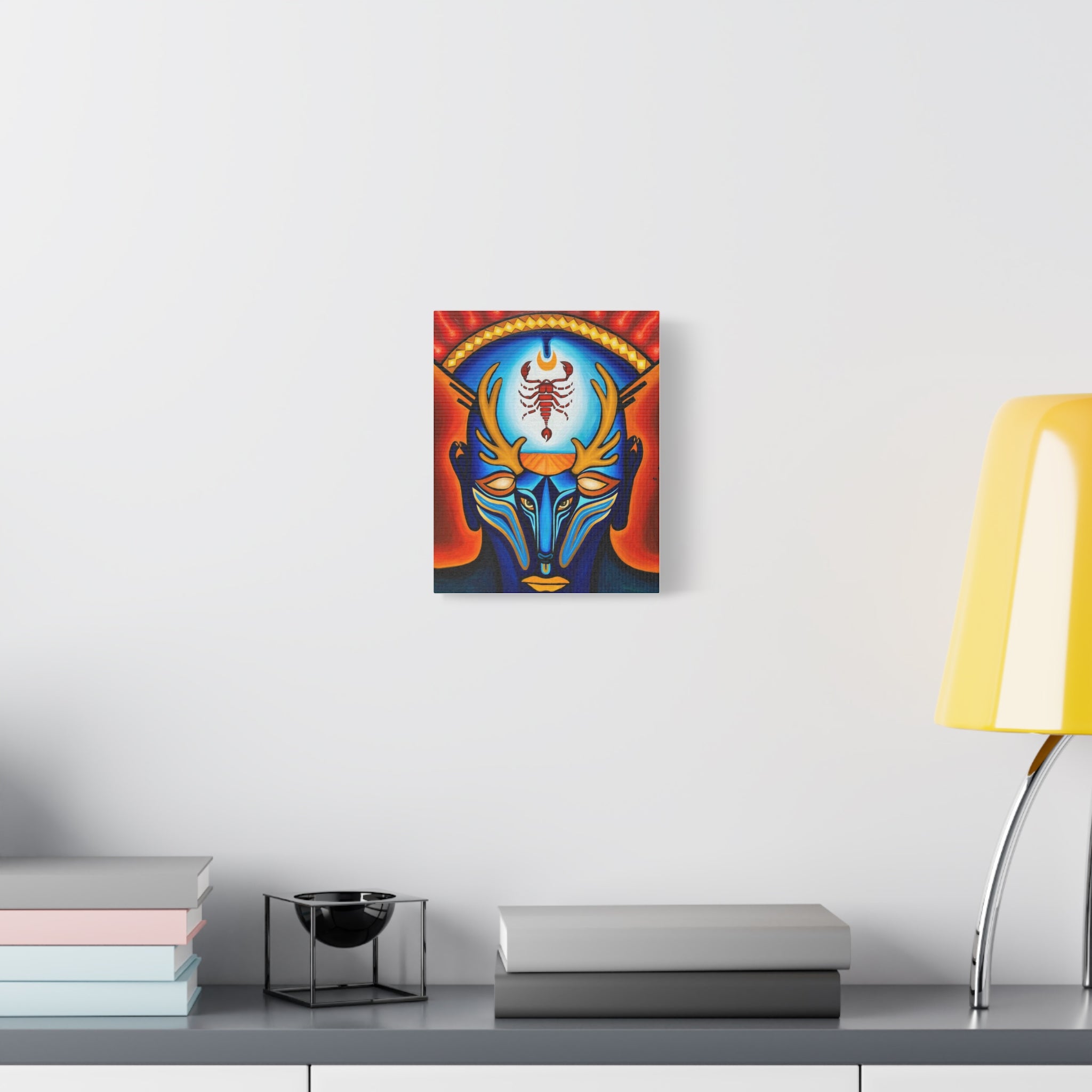 Canvas print of a colorful scorpion design on a wall above a desk with books and a lamp.